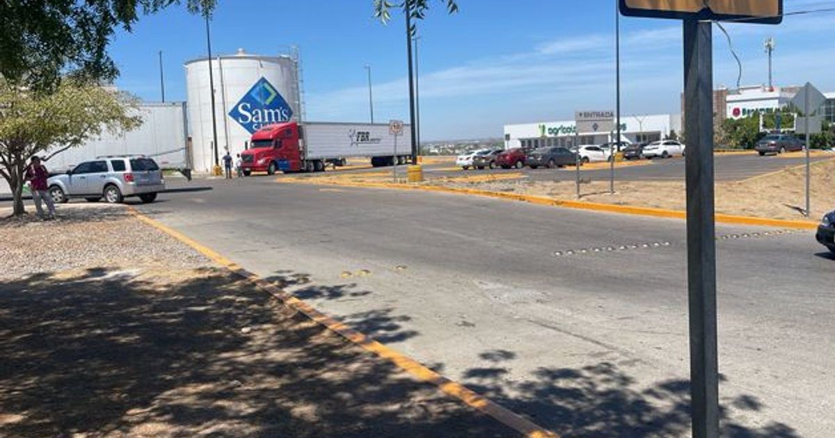 Calle en Culiacán con tanque de Sam's Club y vehículos, escenario de un enfrentamiento armado.