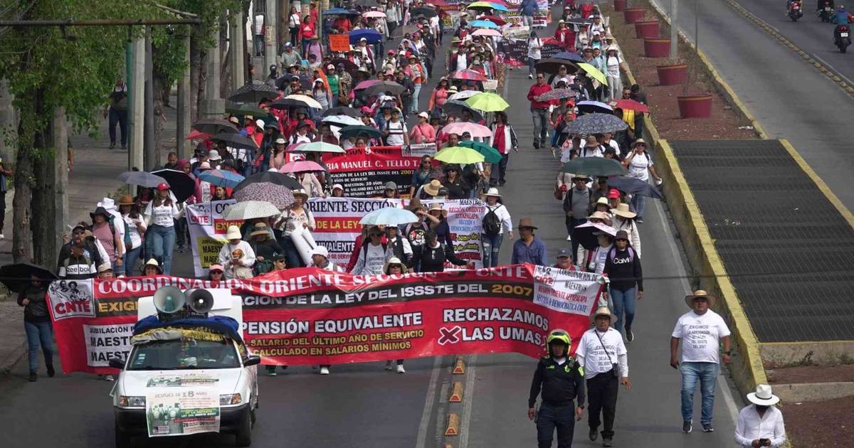 Manifestantes de la CNTE con pancartas y paraguas en protesta contra la Ley del ISSSTE de 2007