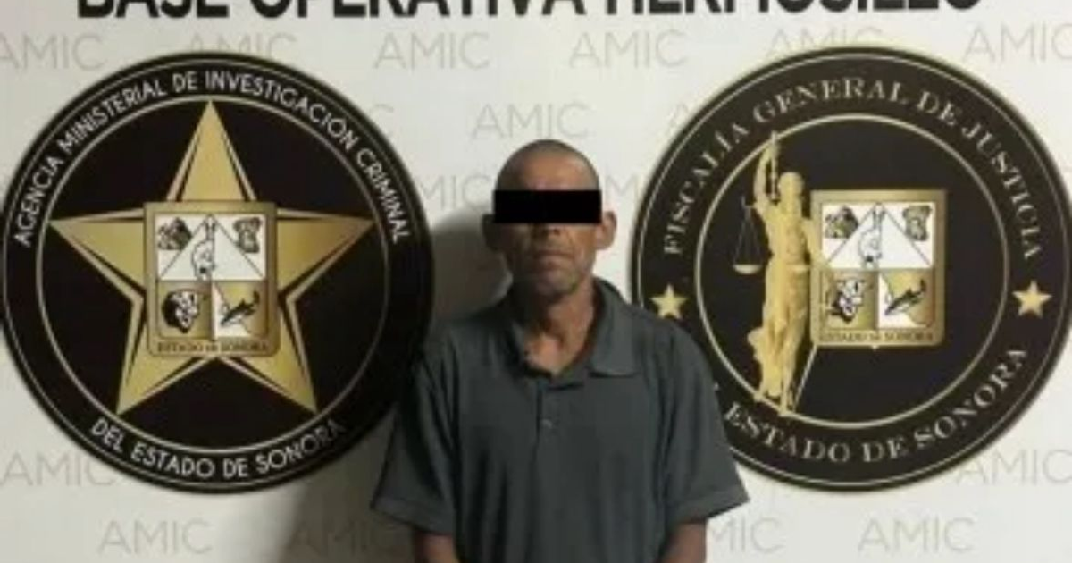 Hombre en oficina de policía con emblemas de la Agencia Ministerial de Investigación Criminal y Fiscalía de Sonora