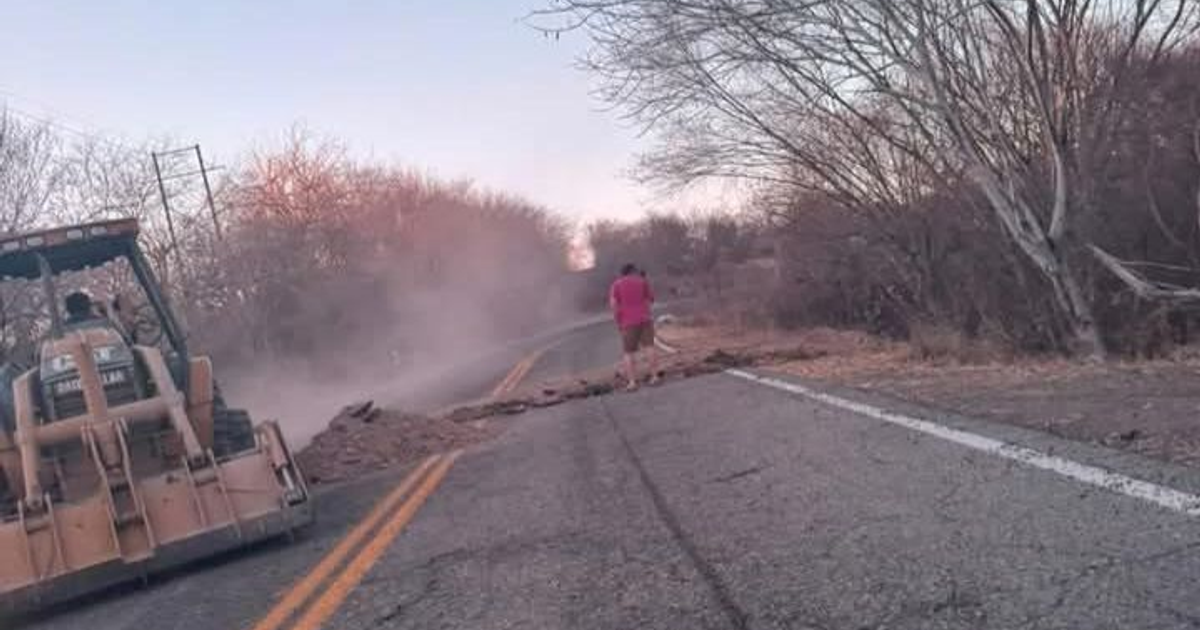 Retroexcavadora levantando escombros en carretera polvorienta de Surutato, Badiraguato.