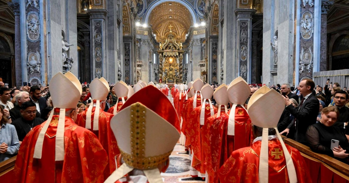 Cardenales en túnicas rojas y mitras blancas durante una ceremonia en la basílica del Vaticano.