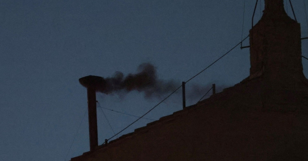 Humo oscuro saliendo de una chimenea en el Vaticano durante el cónclave papal.