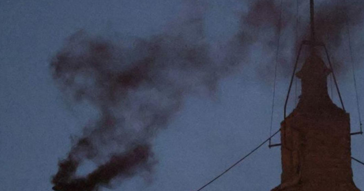 Humo negro saliendo de la chimenea de la Capilla Sixtina durante el cónclave papal nocturno.