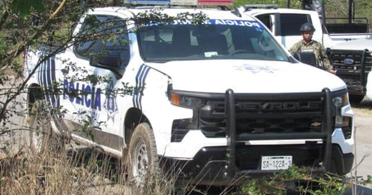 Camioneta policial Chevrolet con oficial en entorno natural, relacionada con búsqueda de desaparecidos en Mazatlán.
