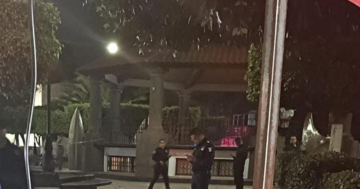 Agentes de policía en Santiago Teyahualco durante la noche, con una estructura arquitectónica al fondo.