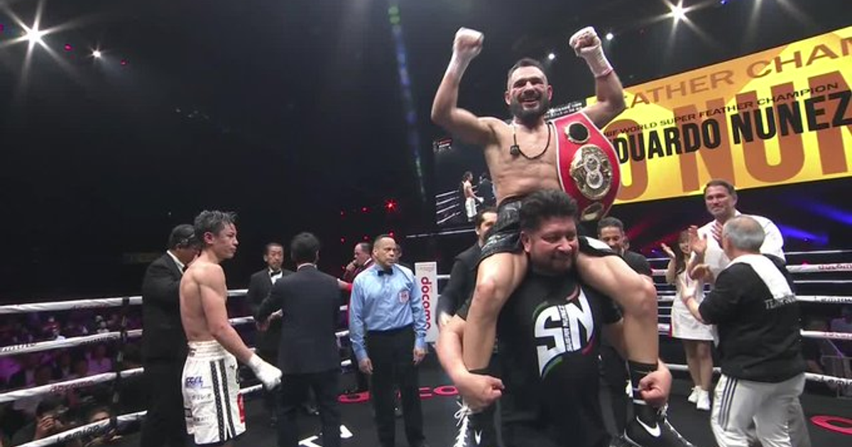 Eduardo “Sugar” Núñez celebra su victoria en el campeonato mundial superpluma, levantado a hombros con el cinturón de campeón.