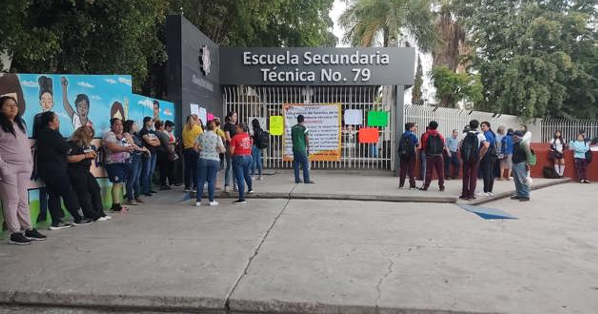 Entrada de la Escuela Secundaria Técnica No. 79 con estudiantes y adultos durante un evento relacionado con protestas educativas.