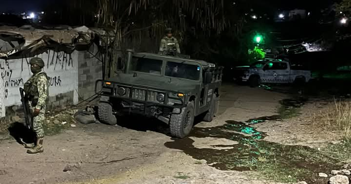 Vehículo militar Humvee y soldado armado en escena nocturna urbana