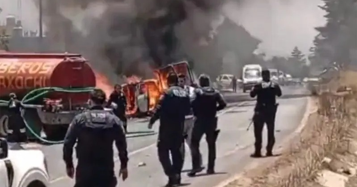 Camión volcado en llamas en la carretera México-Tuxpan, con policías y bomberos presentes.