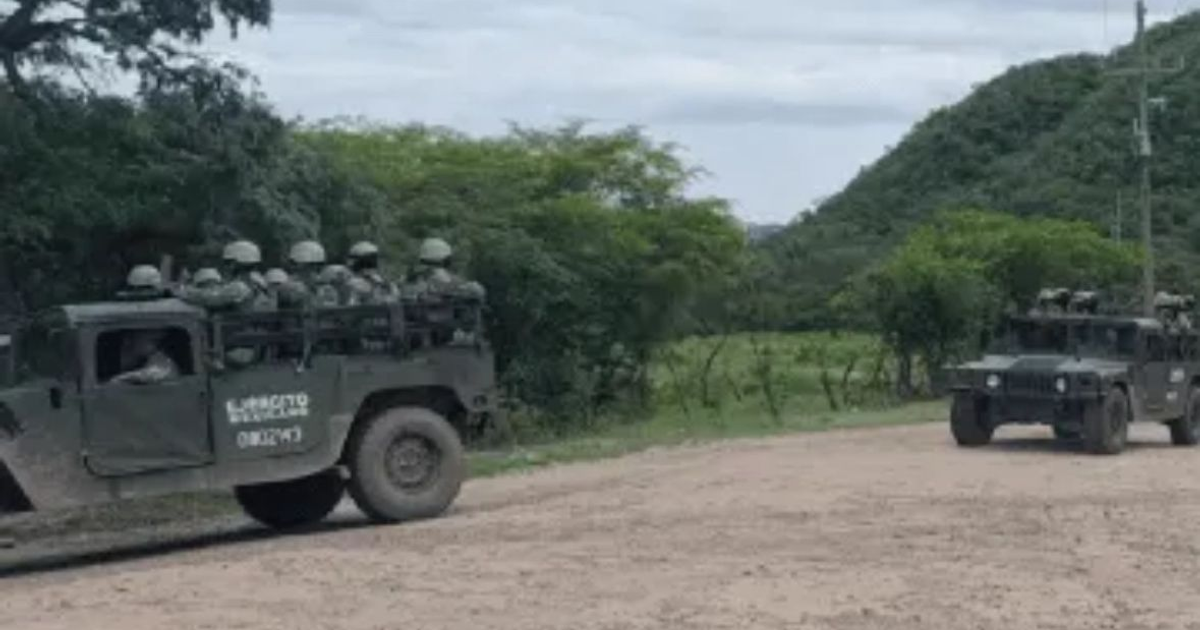 Dos Humvees militares en camino rural con soldados, colinas y cielo nublado al fondo.