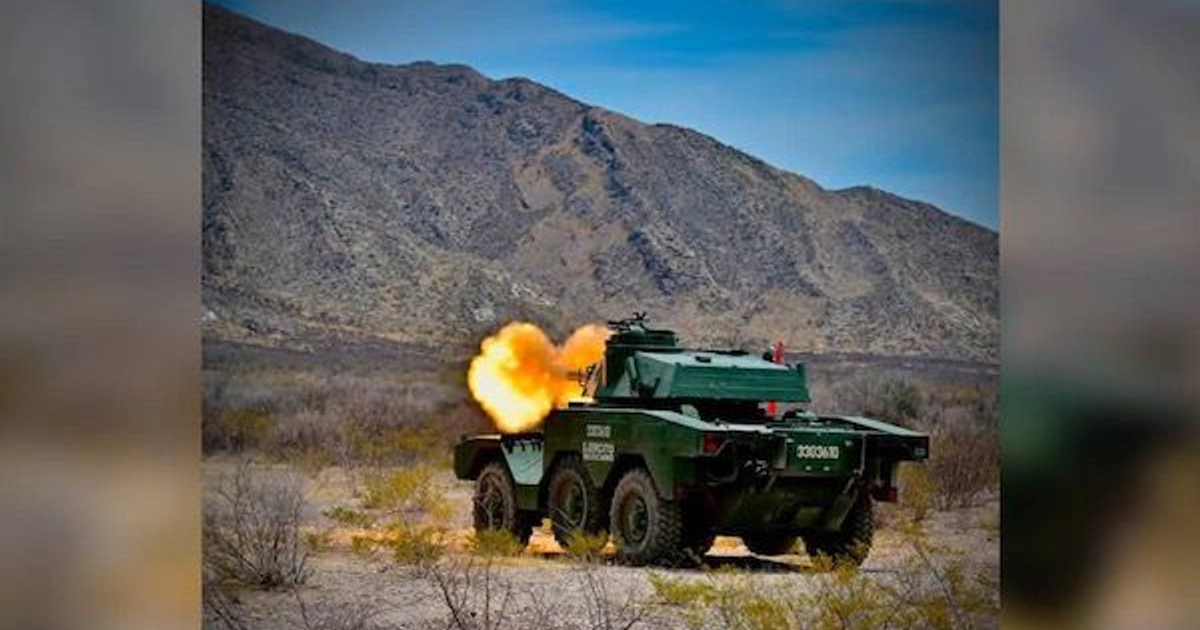 Vehículo militar blindado disparando en paisaje árido durante entrenamiento conjunto en Chihuahua.