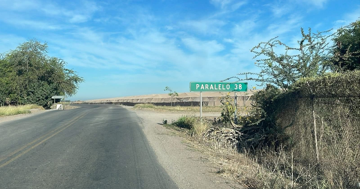 Carretera en el Paralelo 38 con señal de tráfico y vegetación, relacionada con un hallazgo de cadáver en Culiacán.