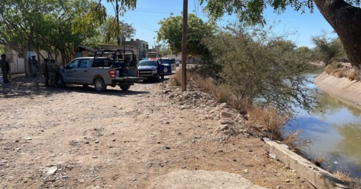 Área rural en Culiacán con vehículos y personal de seguridad cerca de un canal de agua.