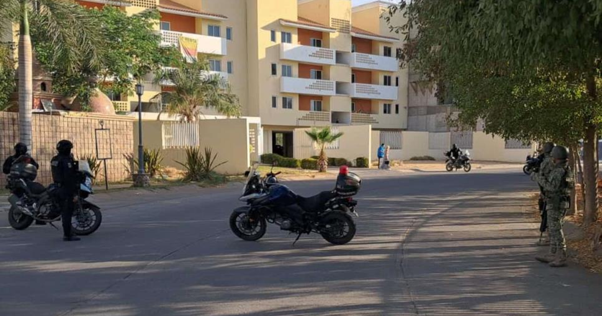 Agentes de seguridad en motocicletas frente a un edificio en Culiacán durante un operativo.