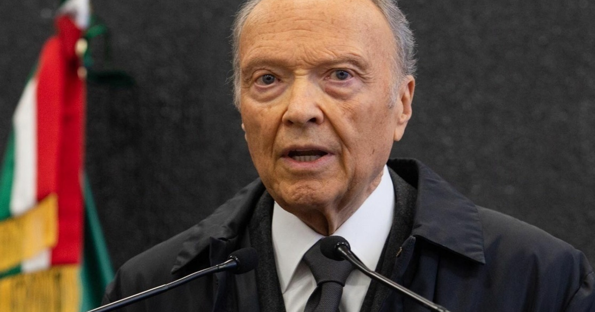 Fiscal Alejandro Gertz Manero hablando en un evento con una bandera de fondo