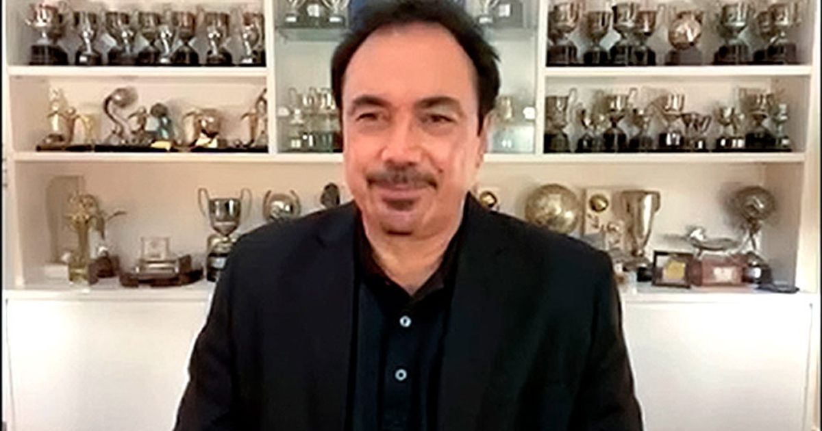 Hugo Sánchez en videoconferencia con trofeos detrás, discutiendo cambios en reglas de fútbol.