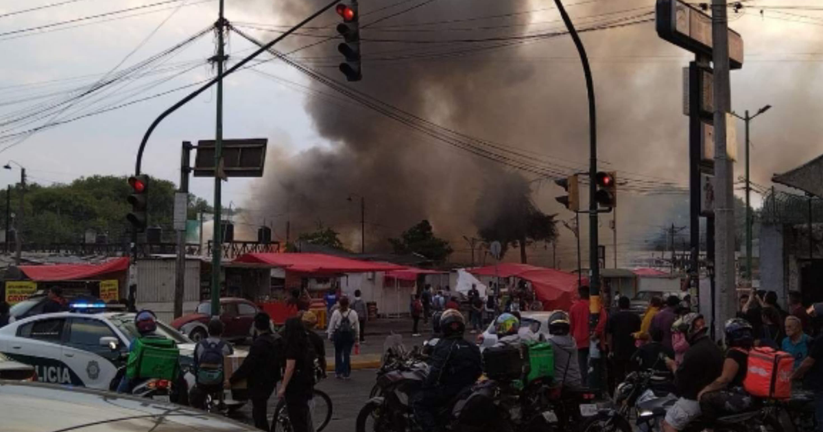 Escena de incendio en metro Lindavista con humo, personas y vehículo de policía