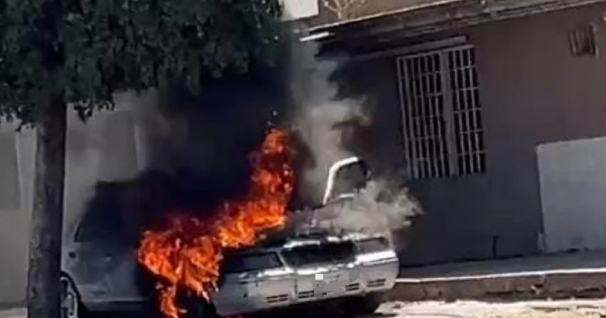 Automóvil en llamas en Culiacán, con humo y llamas visibles, y un edificio al fondo.