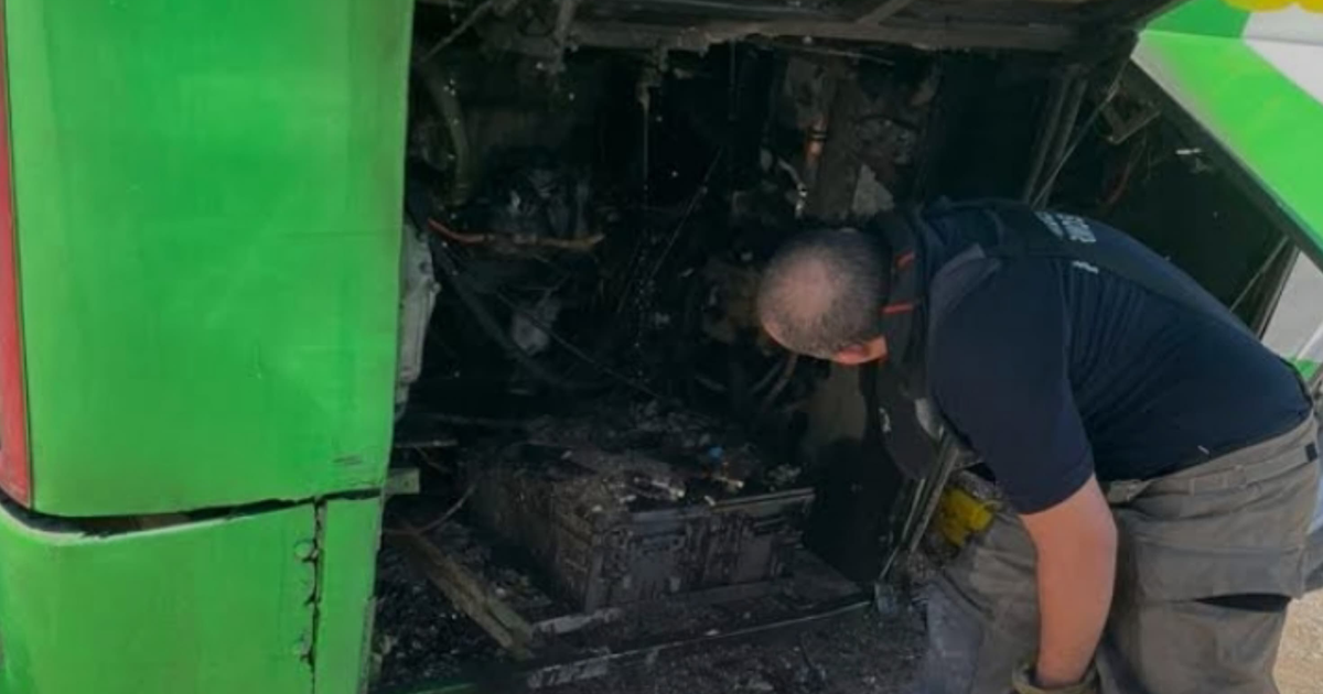 Hombre inspeccionando autobús verde dañado por incendio en Hermosillo