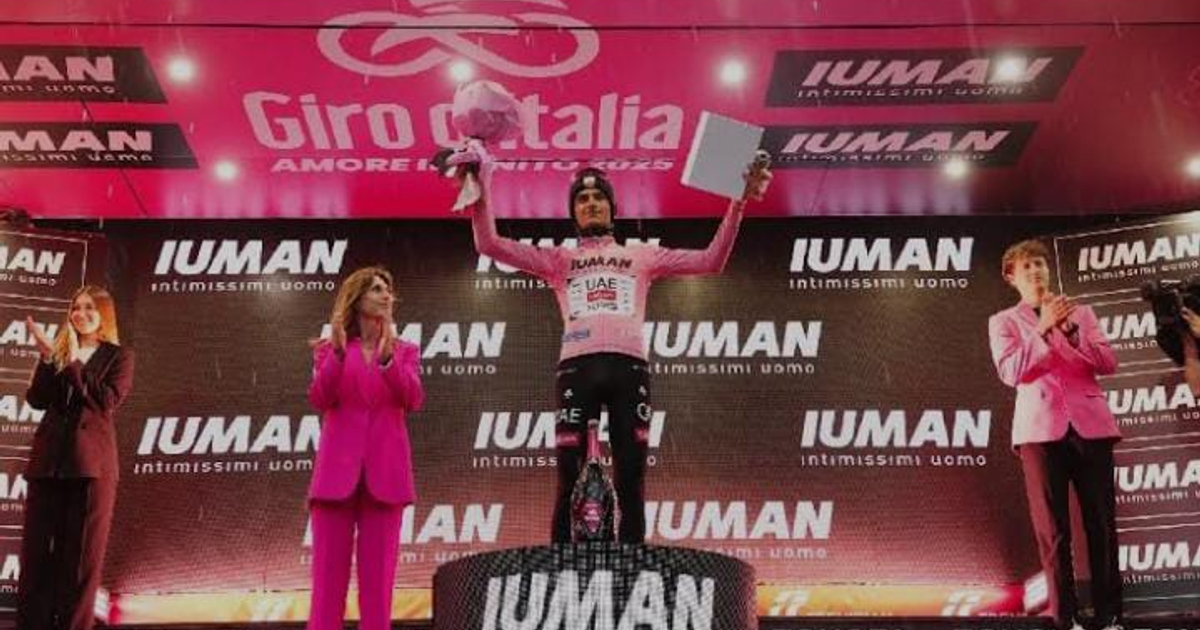 Isaac del Toro en el podio del Giro de Italia 2025 con maglia rosa, trofeo y flores