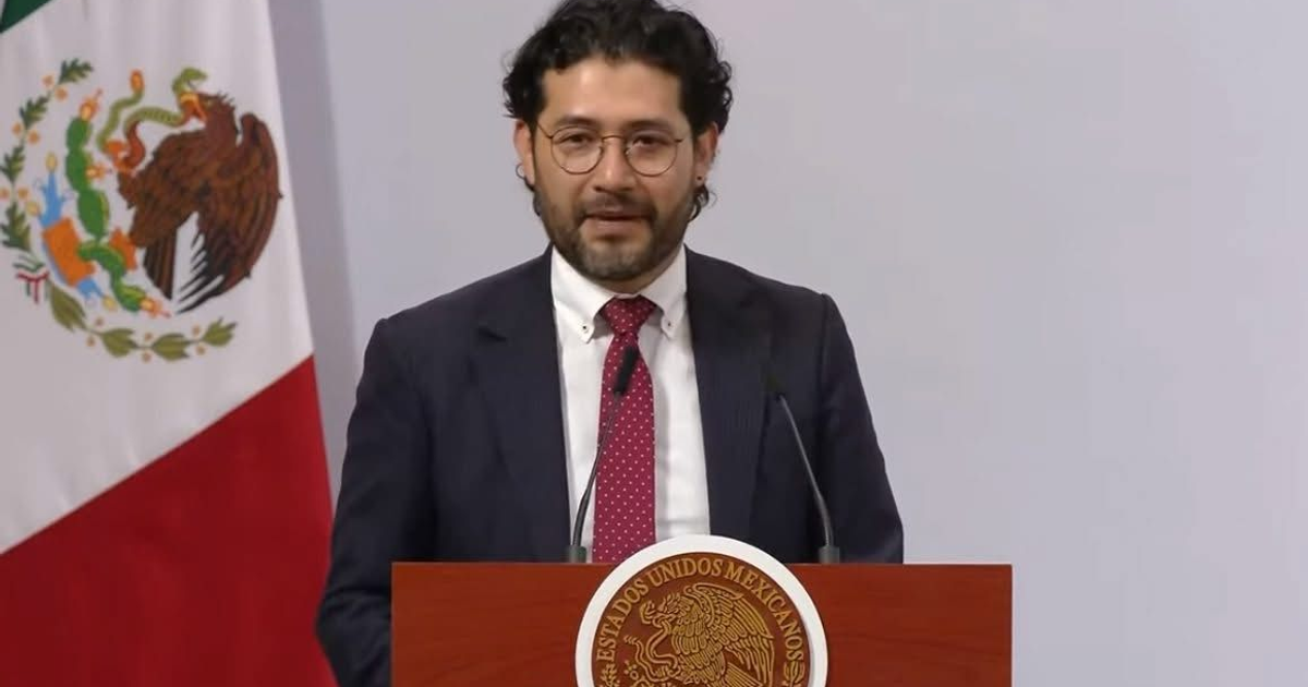 Hombre en traje hablando en un podio con bandera de México, relacionado con la semana laboral de 40 horas.