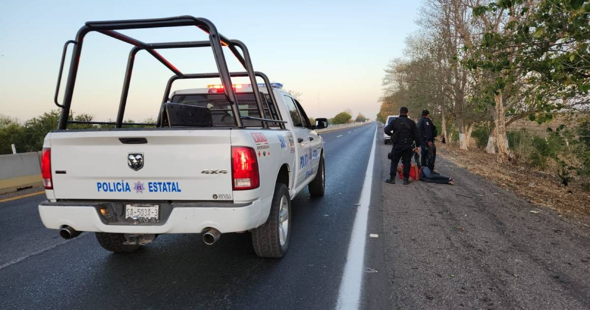 Carretera rural con vehículo policial y agentes en escena de intervención.