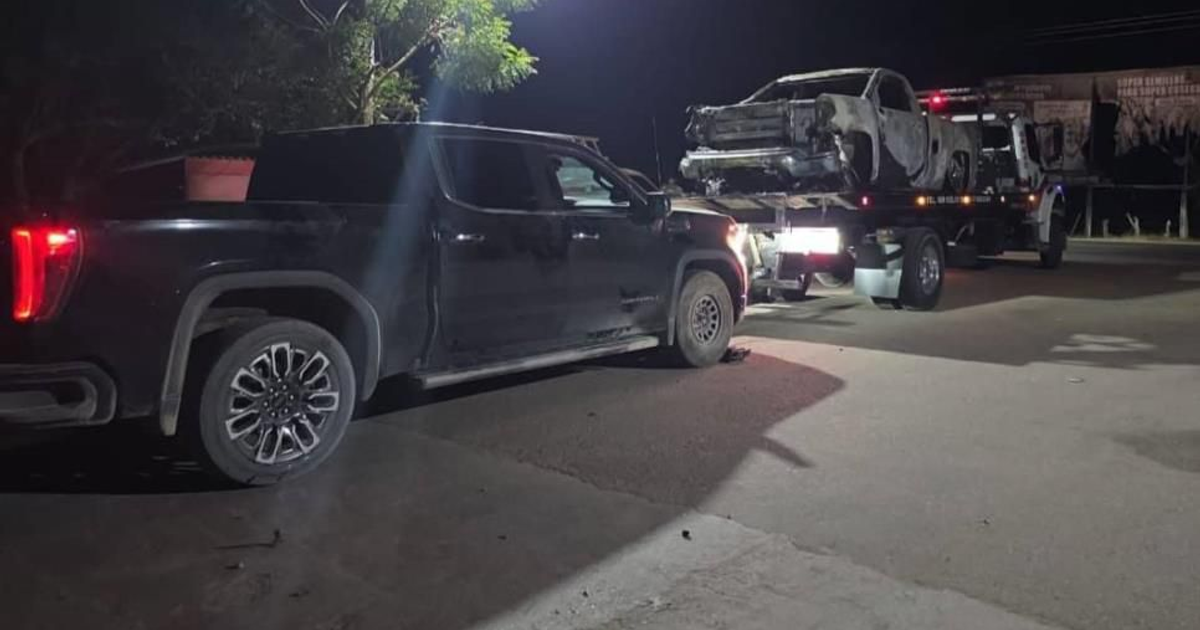 Camioneta negra y camión de remolque con vehículo dañado en operativo nocturno en Sinaloa