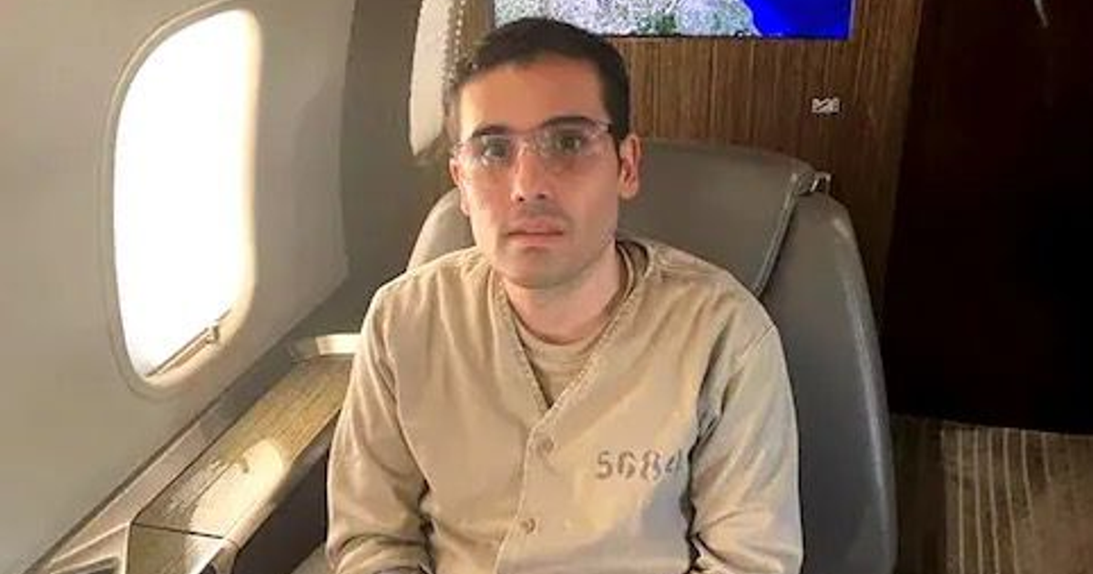 Persona sentada en un avión privado con ventana al fondo, ambiente lujoso.