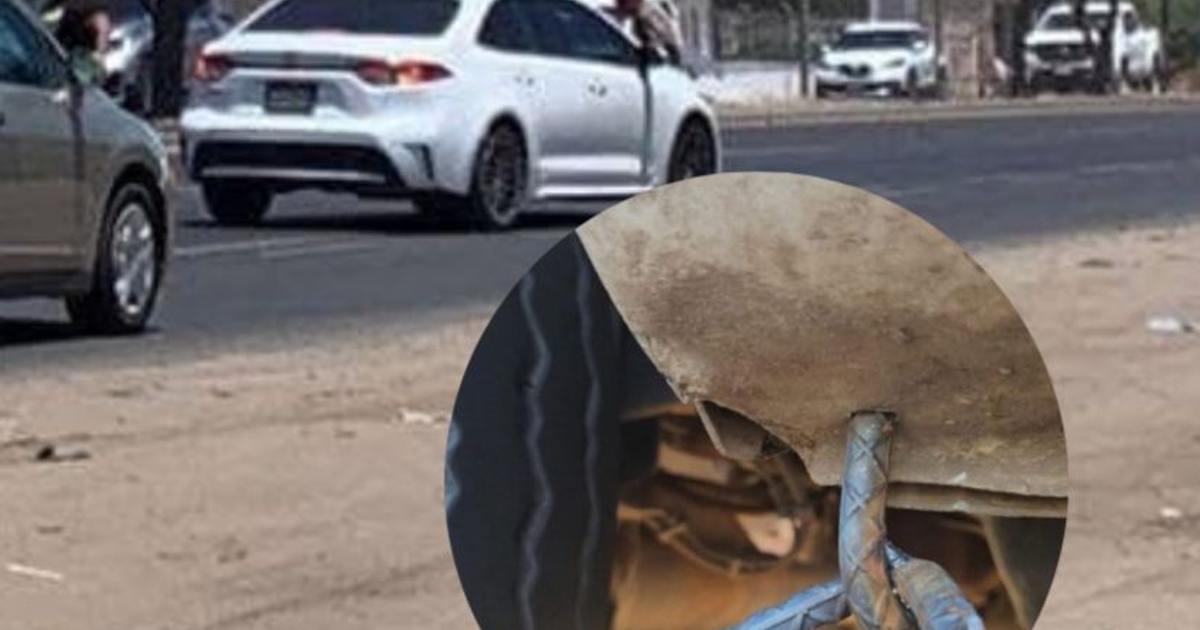 Carretera en Mazatlán con vehículos dañados por ponchallantas, mostrando reparación improvisada en suspensión de un auto.
