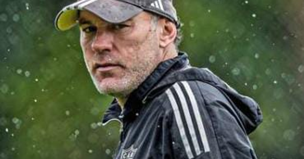 Hombre con abrigo oscuro y gorro en un entorno deportivo, posiblemente Gabriel Milito en Verde Valle.