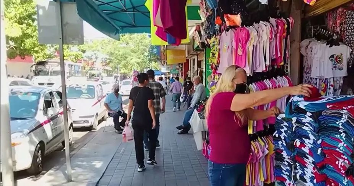 Calle comercial en Culiacán con mercado al aire libre y medidas de seguridad