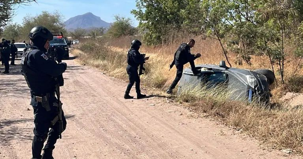 Agentes de seguridad investigan un vehículo volcado en un camino de tierra tras una persecución en Culiacán.