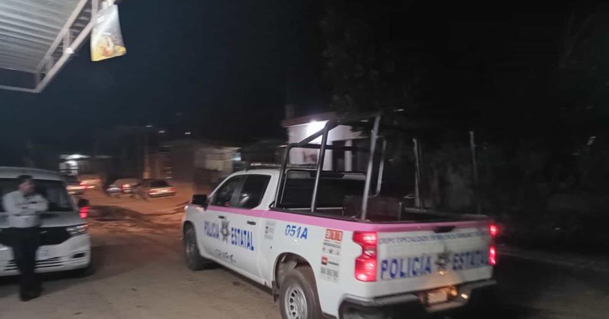 Camioneta de la Policía Estatal y vehículos estacionados en una calle nocturna de Alturas del Sur, Culiacán.