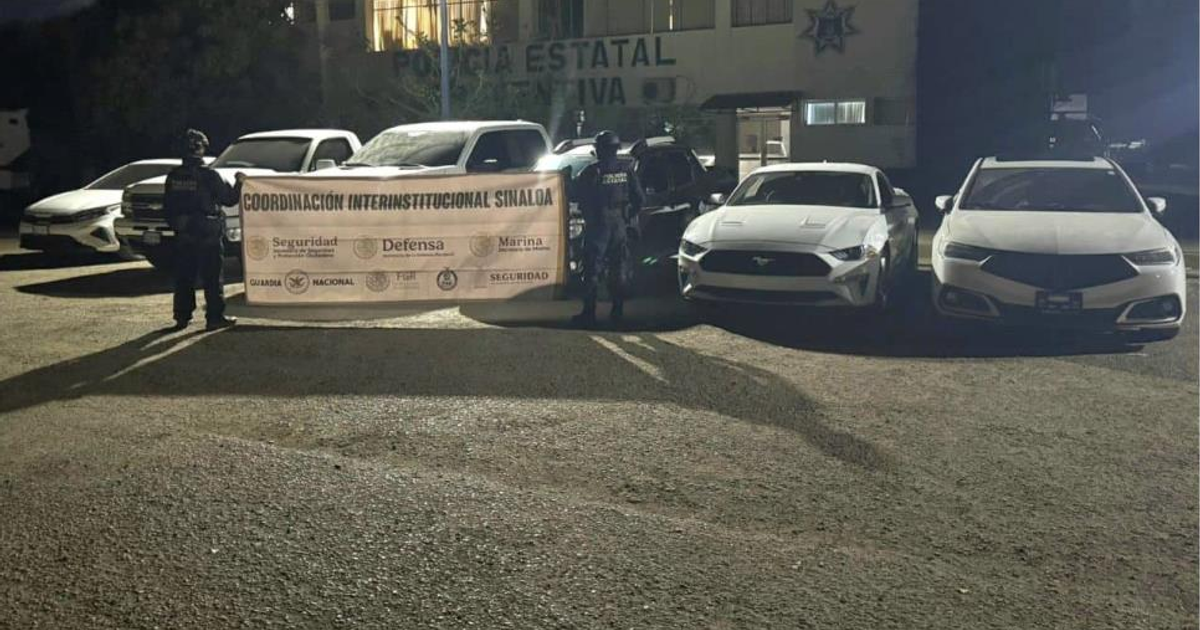 Agentes de seguridad con pancarta de coordinación interinstitucional en Culiacán, junto a vehículos durante la noche.