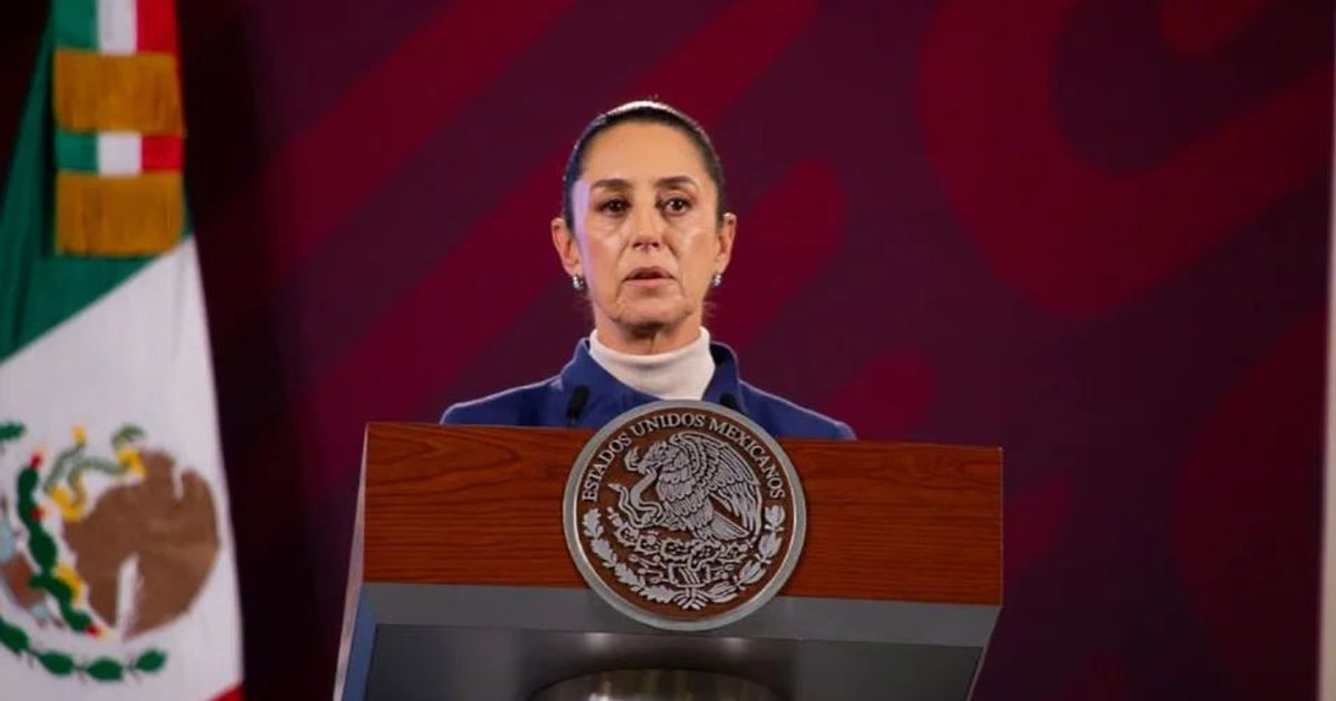 Claudia Sheinbaum hablando en un podio con bandera de México detrás