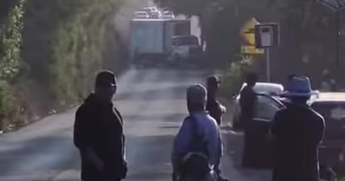 Carretera con personas y camión, escena relacionada con crimen en Villa Madero