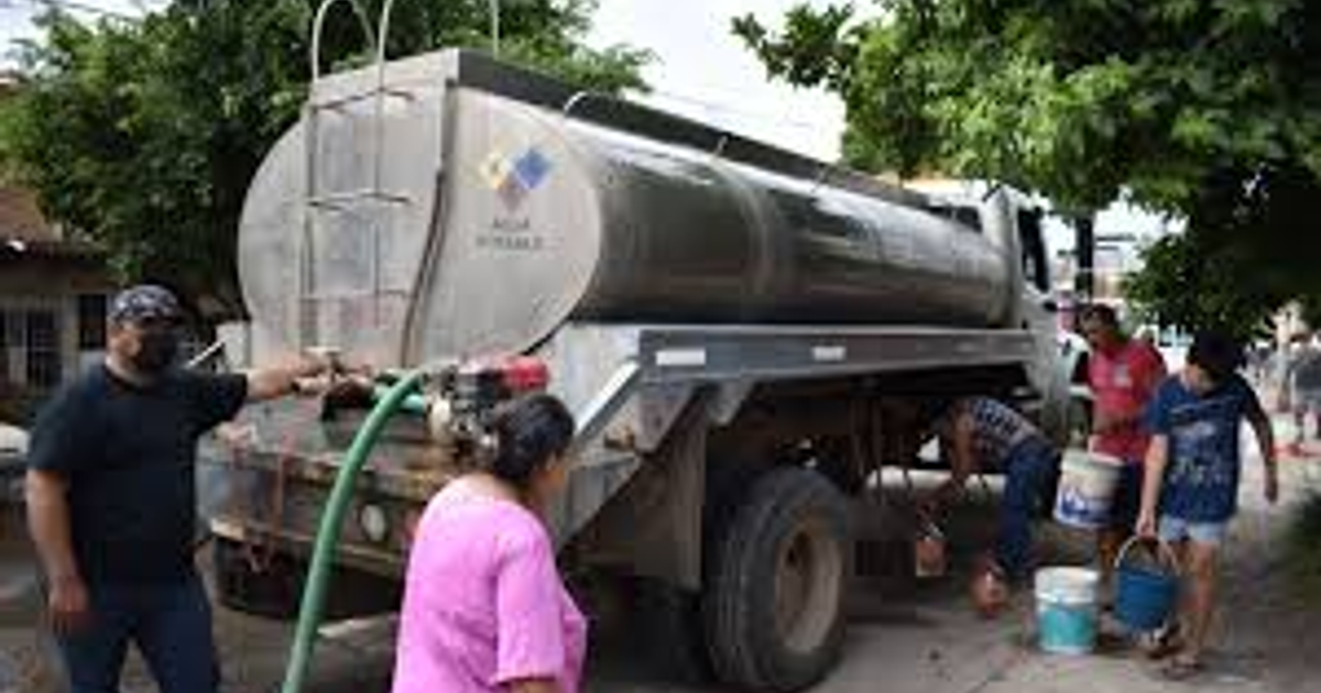 Camión cisterna distribuyendo agua potable en Mazatlán durante la sequía, con personas recogiendo agua en cubos.