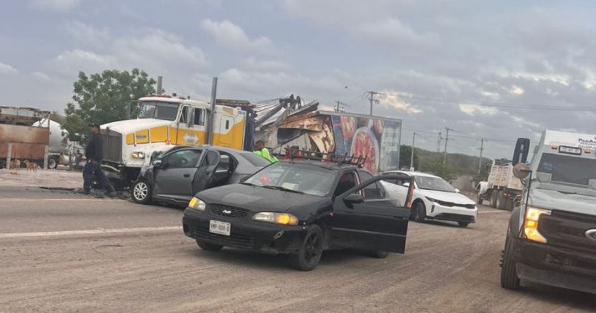 Accidente de tráfico en carretera con varios vehículos involucrados, incluyendo un tráiler y un coche negro con la puerta abierta.