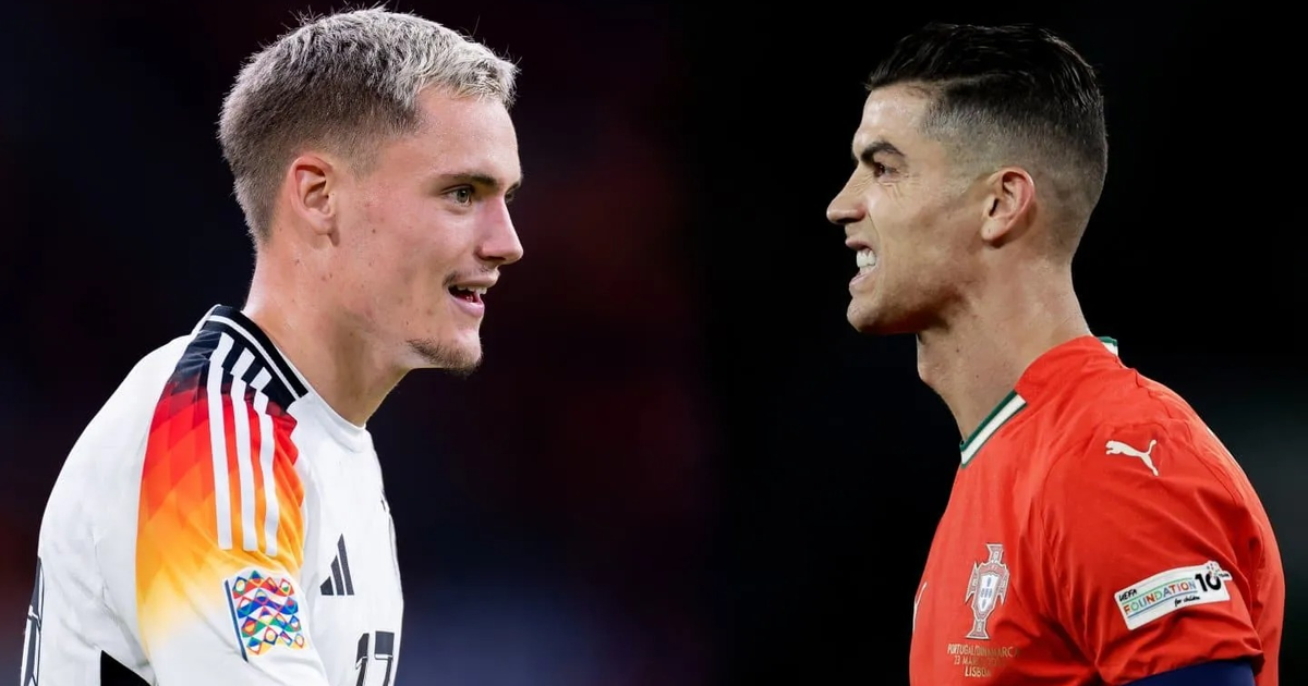 Dos futbolistas de perfil, uno con camiseta blanca y otro con camiseta roja, en un partido de fútbol.