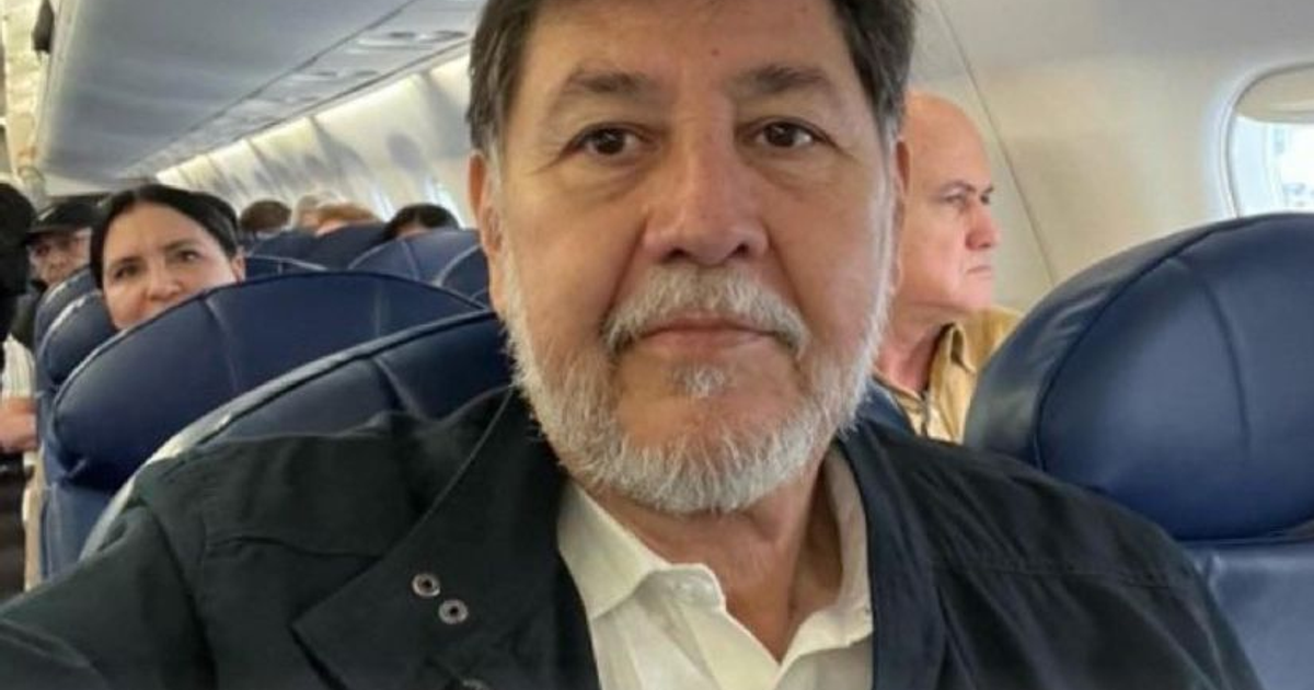 Hombre canoso sentado en un avión, relacionado con amenazas en redes sociales.