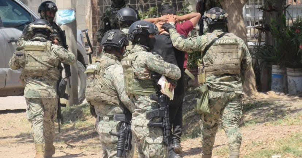 Miembros de la marina detienen a un sospechoso en Mazatlán, equipados con equipo táctico y armas.