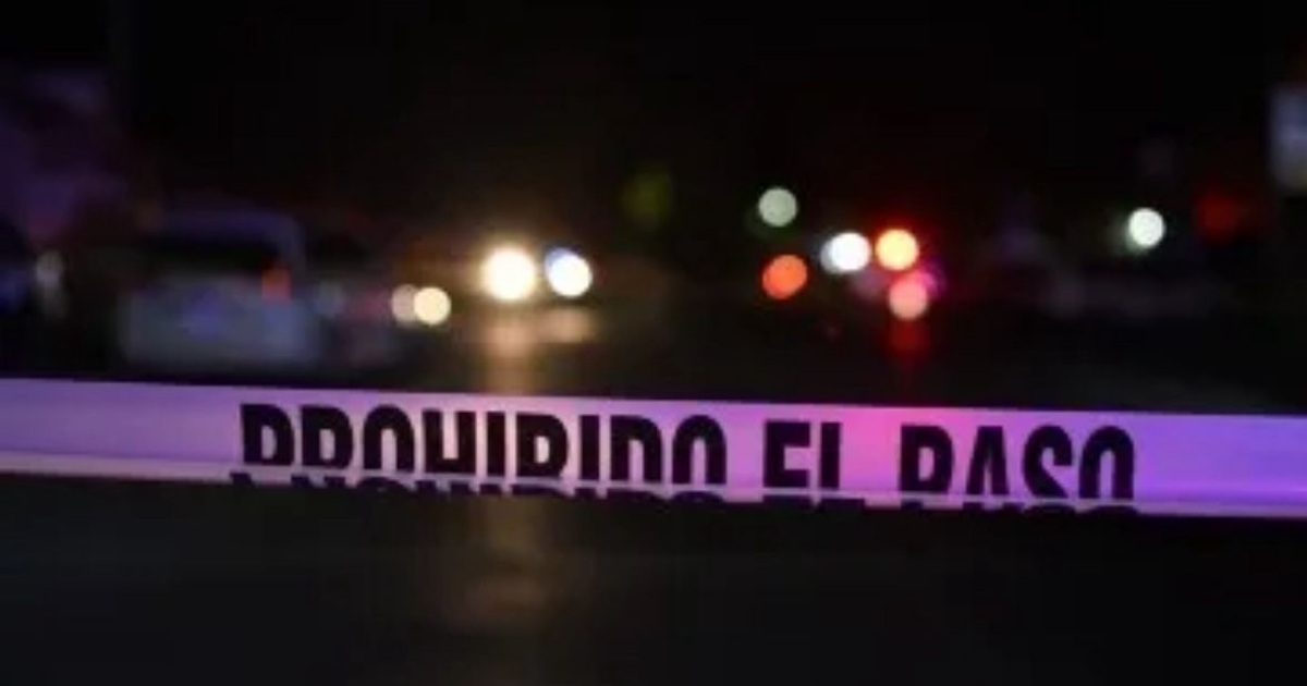 Cinta de restricción 'PROHIBIDO EL PASO' en escena nocturna con luces de vehículos, relacionada con incidente en Feria del Elote.