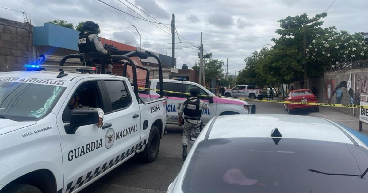 Vehículos de la Guardia Nacional y policía en escena de crimen en Culiacán, con cinta amarilla delimitando el área.