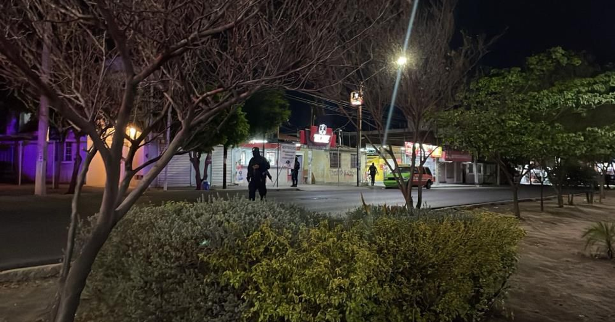 Calle nocturna en Culiacán con vehículo verde y luces artificiales, relacionada con un ataque armado.