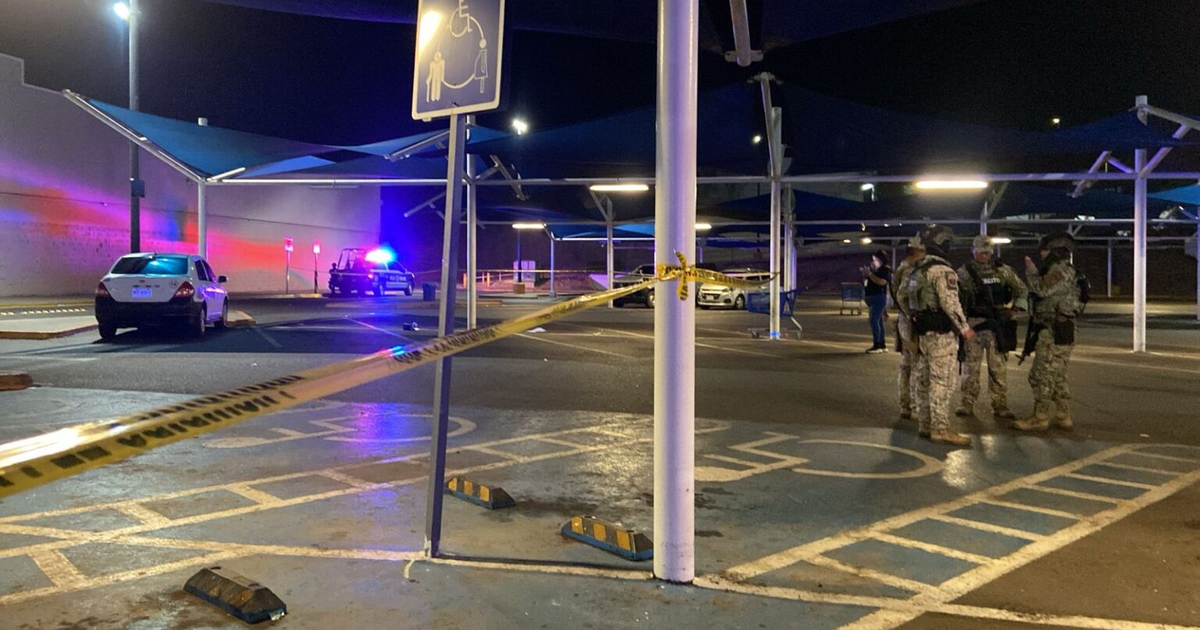 Operativo policial nocturno en estacionamiento con vehículos y cinta amarilla.