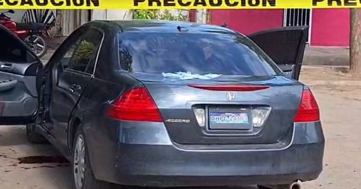 Automóvil gris oscuro con puertas abiertas y cinta de precaución amarilla, vinculado a un tiroteo en Navolato.