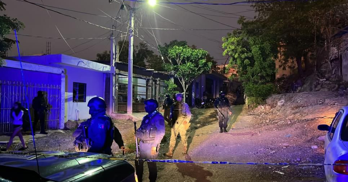 Agentes de seguridad patrullan una calle urbana de noche tras un ataque armado en Culiacán.