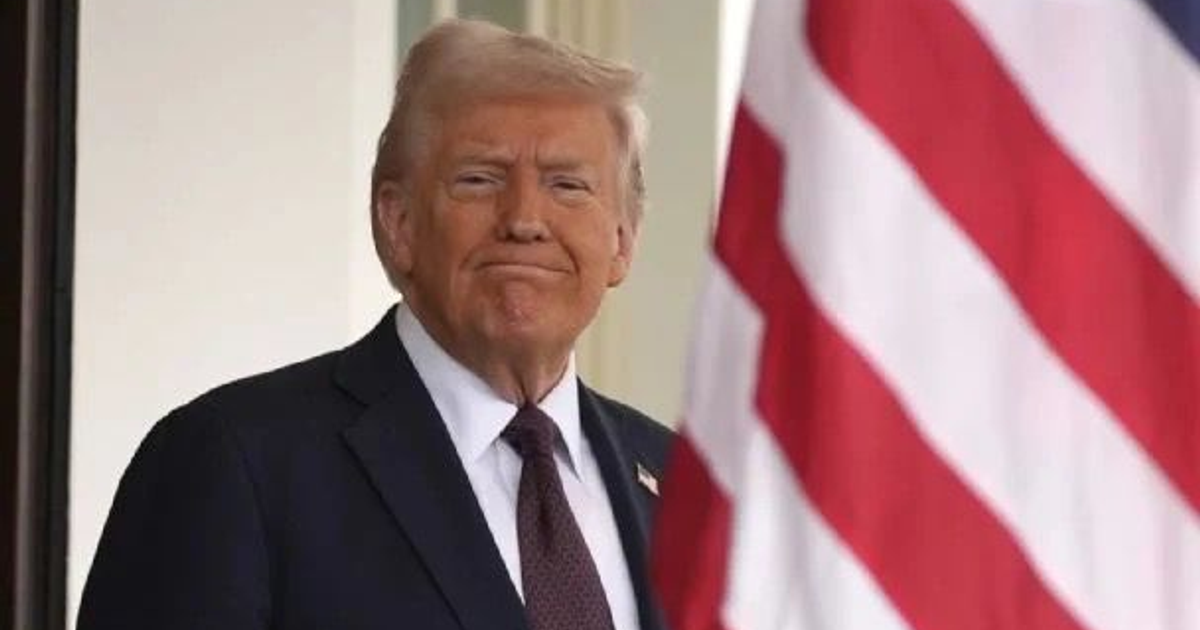 Persona en un entorno de vigilancia cerca de una bandera, simbolizando la presión de EE.UU. sobre Irán.