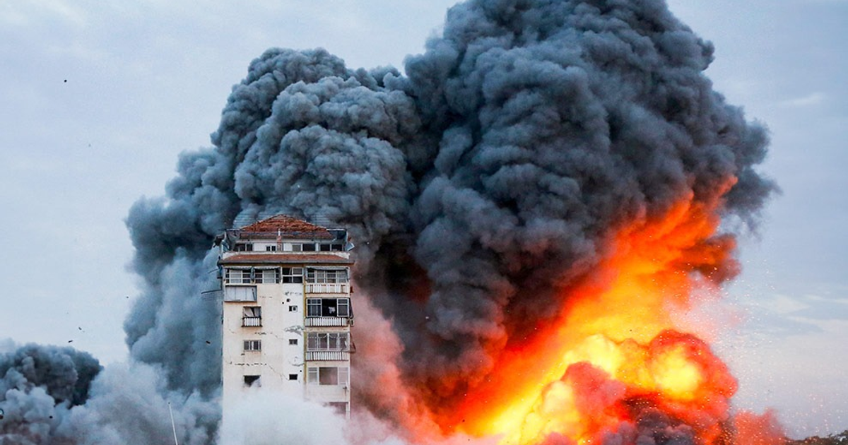 Explosión en edificio durante ataques aéreos en Irán, con humo y llamas visibles.