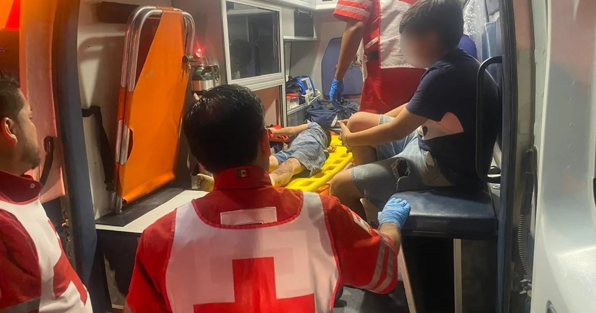 Paramédicos atienden a un herido en una ambulancia tras accidente en Guasave